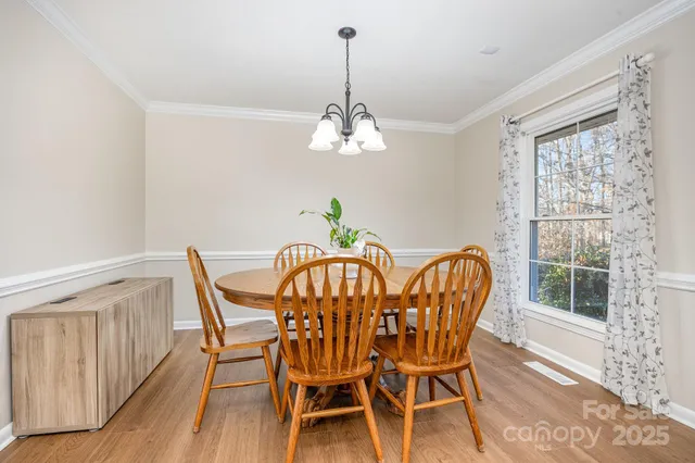 a dining room with furniture a chandelier and wooden floor