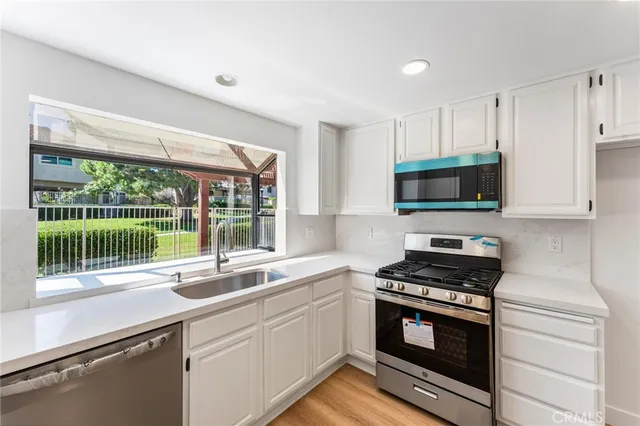 a kitchen with stainless steel appliances a stove sink and microwave
