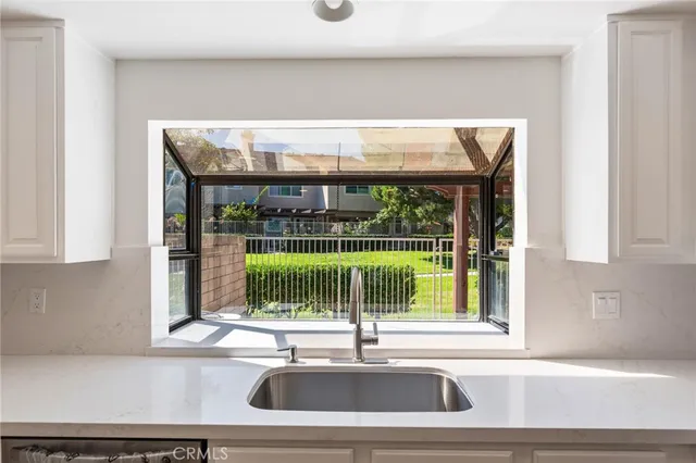 a view of a kitchen with a sink and large window