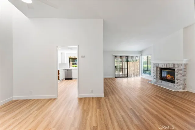 a view of an empty room with window and fire place