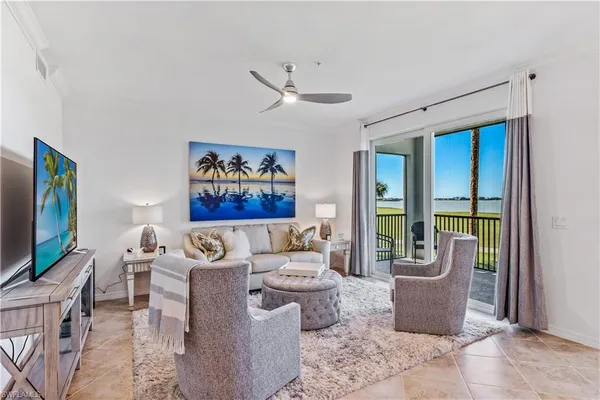 a living room with furniture a flat screen tv and a window