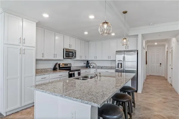 a kitchen with stainless steel appliances granite countertop a sink refrigerator and cabinets