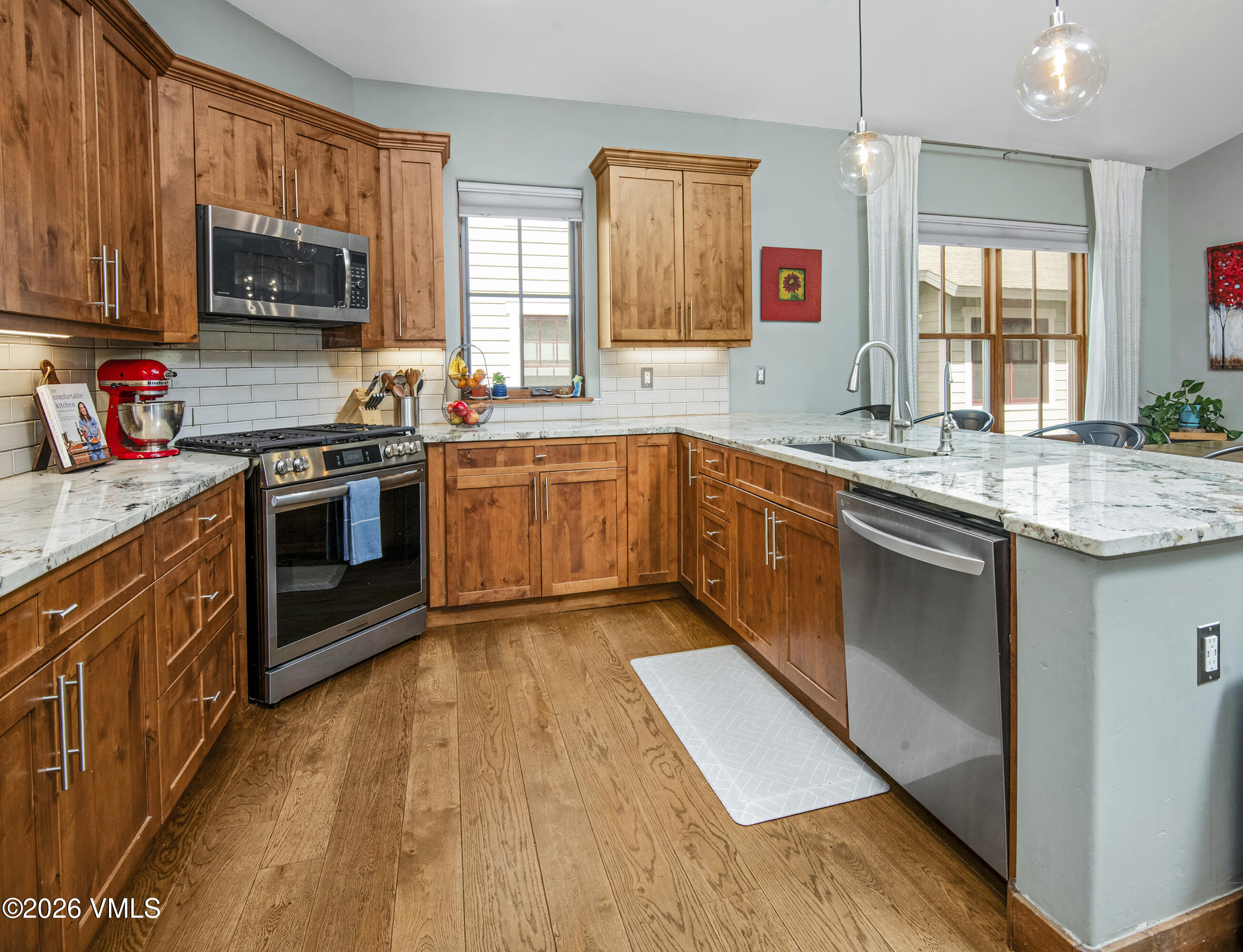 135 Palmer Loop Eagle, CO 81631 - Photo 22 of 54 a kitchen with stainless steel appliances granite countertop wooden cabinets a sink a stove a microwave and wooden floors