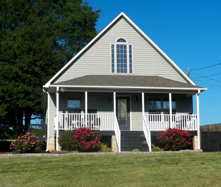 859 Riverview Rd Extension Lexington, NC 27292 - Photo 2 of 26 Flowering knockout rose bushes accent each side of the front stairs to the covered porch and leaded glass entry door. All trim, decks and stairs have new paint/stain.