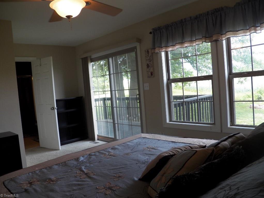 859 Riverview Rd Extension Lexington, NC 27292 - Photo 16 of 26 Another view of the master bedroom shows the back wall with windows and sliding door. Pretty view of the backyard. Door shows entry to the master bedroom.