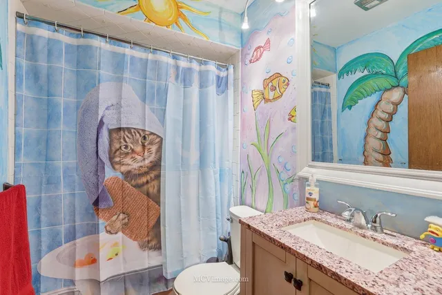 a bathroom with a sink mirror vanity and toilet
