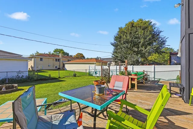 a view of a patio with table and chairs and a barbeque