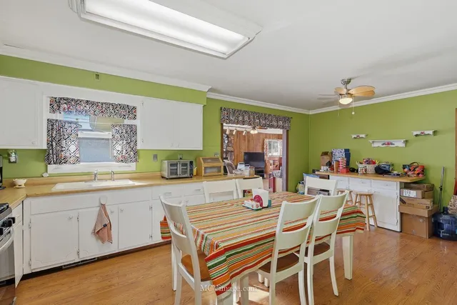 a dining hall with stainless steel appliances a dining table and chairs with wooden floor