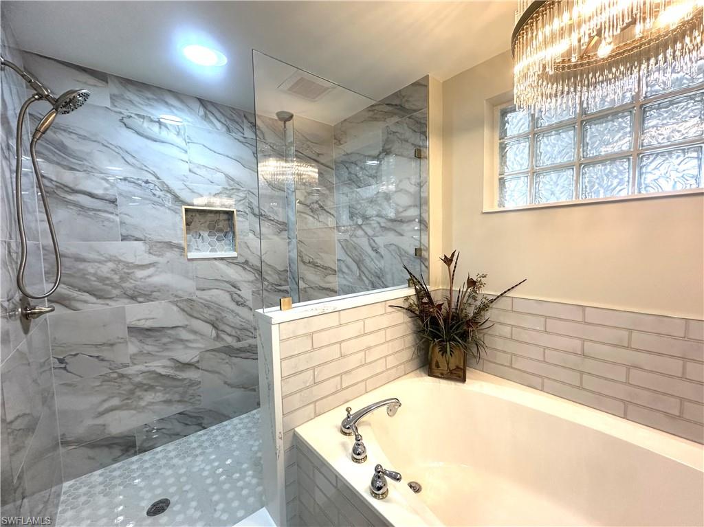 325 Dunes Boulevard, Unit 306 Naples, FL 34110 - Photo 24 of 40 a bath tub sitting in a bathroom next to a window