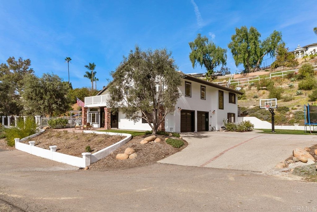 a view of a white house with a large tree