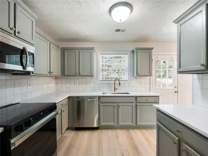 a kitchen with stainless steel appliances a sink stove and cabinets