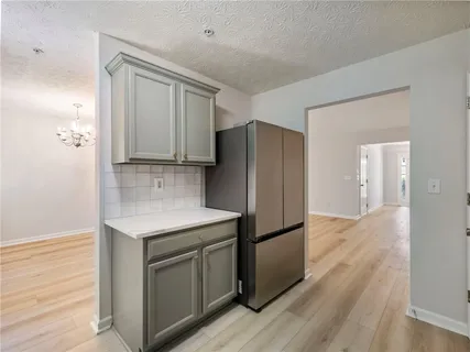 a kitchen with a refrigerator sink and cabinets