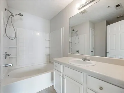 a bathroom with a sink vanity tub and shower