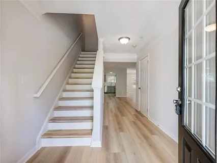 a view of a hallway with wooden floor and entryway
