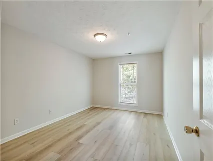 an empty room with wooden floor and window