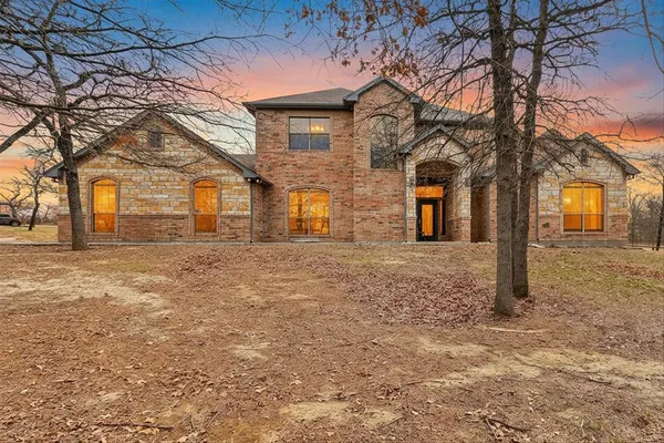 front view of a house with a large tree