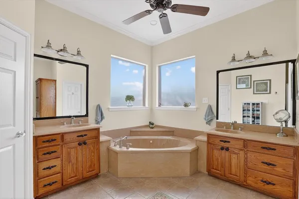 a bathroom with a granite countertop double vanity sink a mirror a and a bathtub