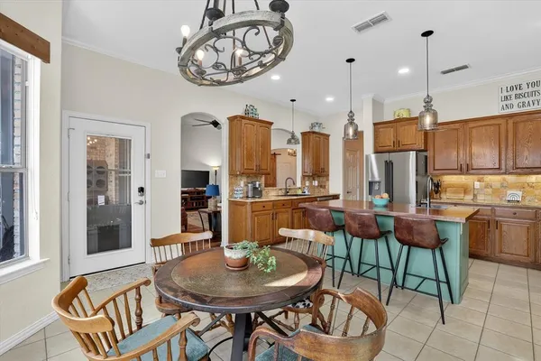 a dining room with furniture a kitchen and chandelier