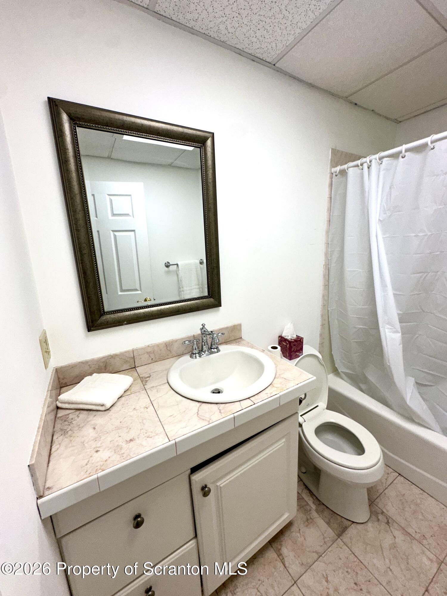436 Ziegler Street Dupont, PA 18641 - Photo 3 of 17 a bathroom with a granite countertop toilet sink and mirror