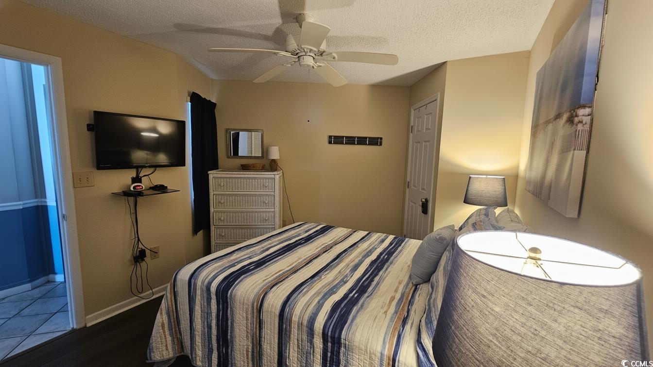1210 North Waccamaw Drive, Unit 512 Murrells Inlet, SC 29576 - Photo 13 of 20 Bedroom with a ceiling fan, a textured ceiling, and wood finished floors