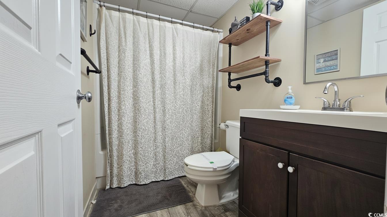 1210 North Waccamaw Drive, Unit 512 Murrells Inlet, SC 29576 - Photo 14 of 20 Bathroom featuring a paneled ceiling, vanity, wood finished floors, and shower / bath combination with curtain