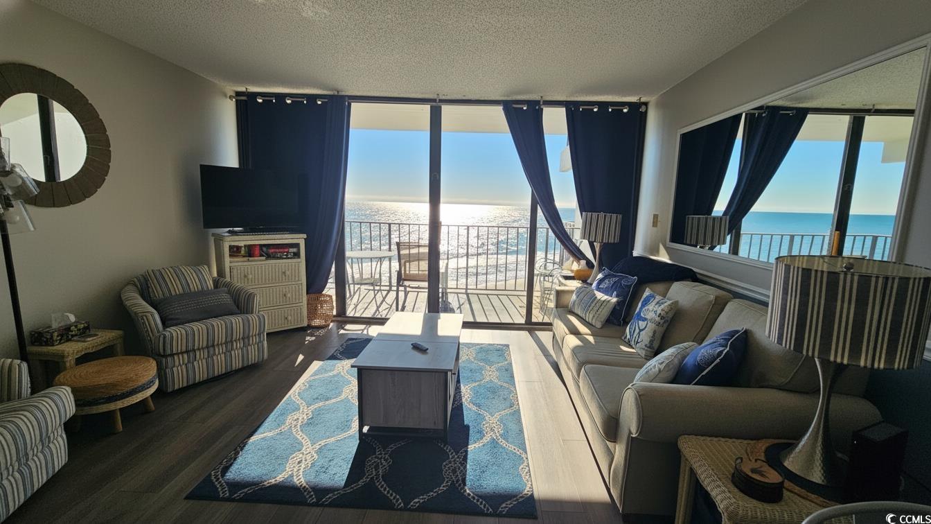 1210 North Waccamaw Drive, Unit 512 Murrells Inlet, SC 29576 - Photo 4 of 20 Living room featuring floor to ceiling windows, a textured ceiling, and wood finished floors