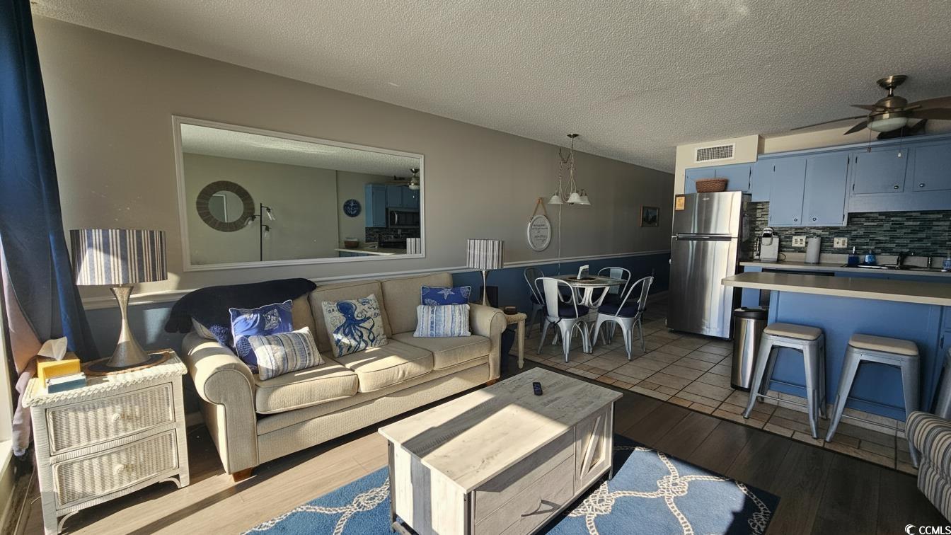 1210 North Waccamaw Drive, Unit 512 Murrells Inlet, SC 29576 - Photo 6 of 20 Living area featuring a textured ceiling, a ceiling fan, and dark wood-style flooring