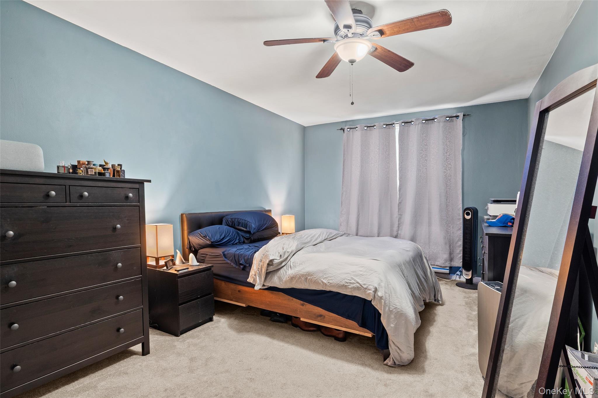 504 Merrick Road, Unit 2K Lynbrook, NY 11563 - Photo 11 of 20 a bedroom with a bed and a chandelier