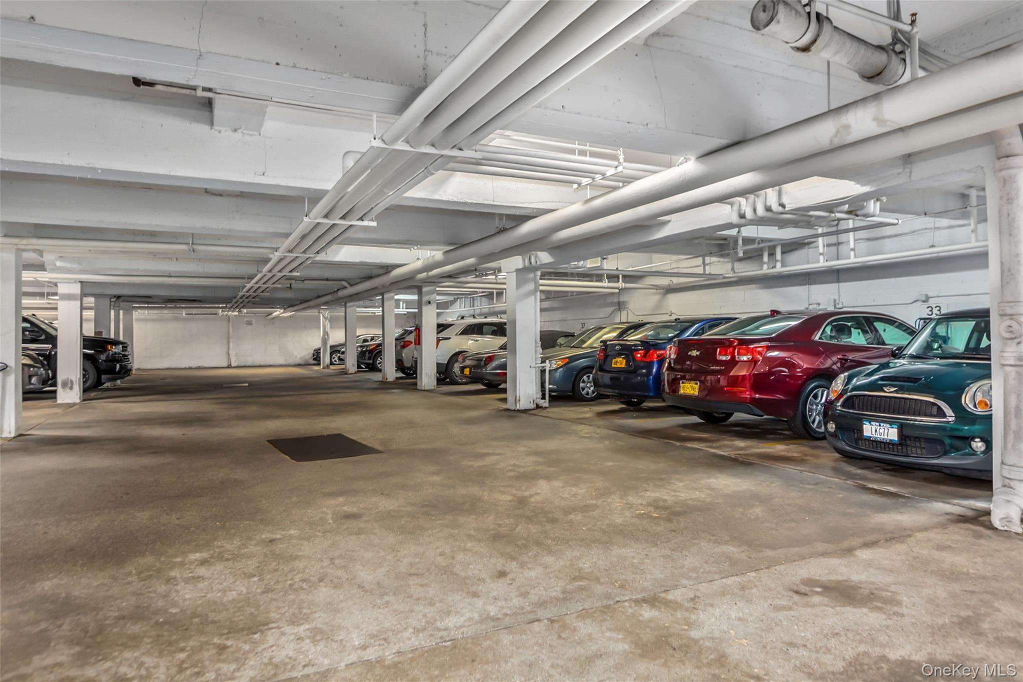 504 Merrick Road, Unit 2K Lynbrook, NY 11563 - Photo 16 of 20 a view of parking garage with cars