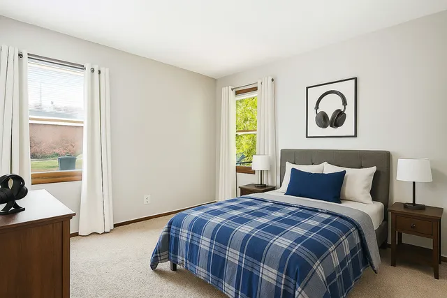 a bedroom with a bed and window with lamp