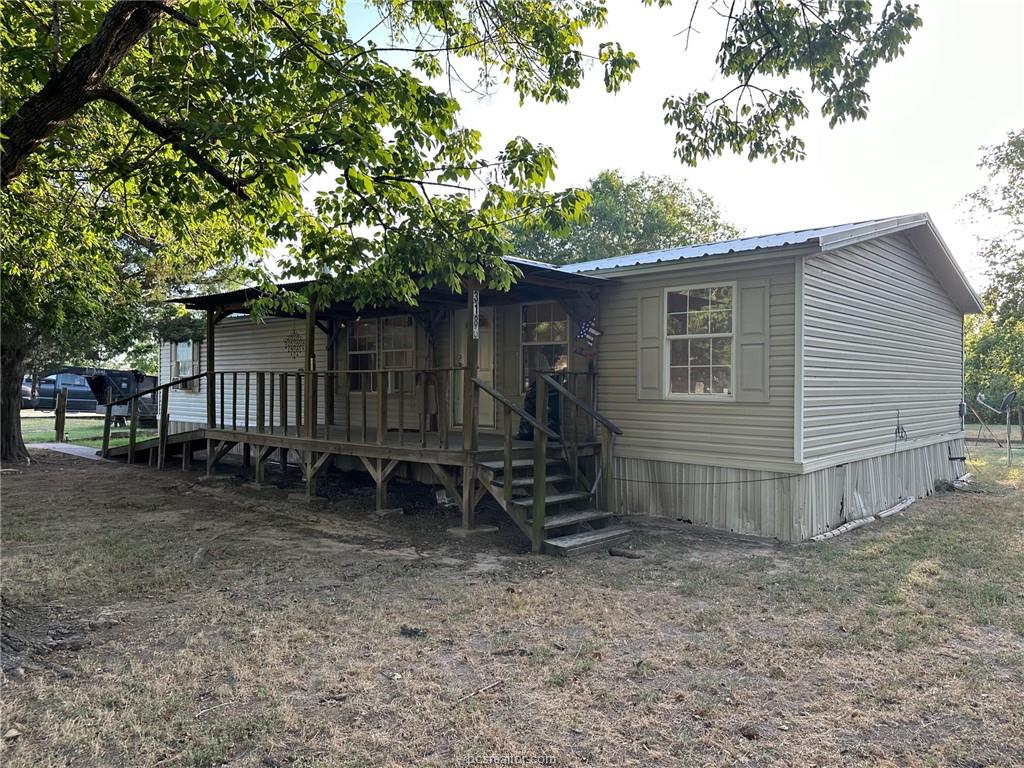3180 Henderson Road Millican, TX 77868 - Photo 1 of 10 a backyard of a house with wooden fence and a tree