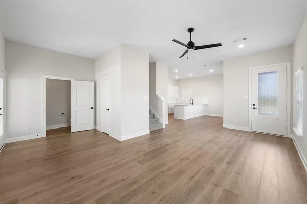 a view of an empty room and a kitchen