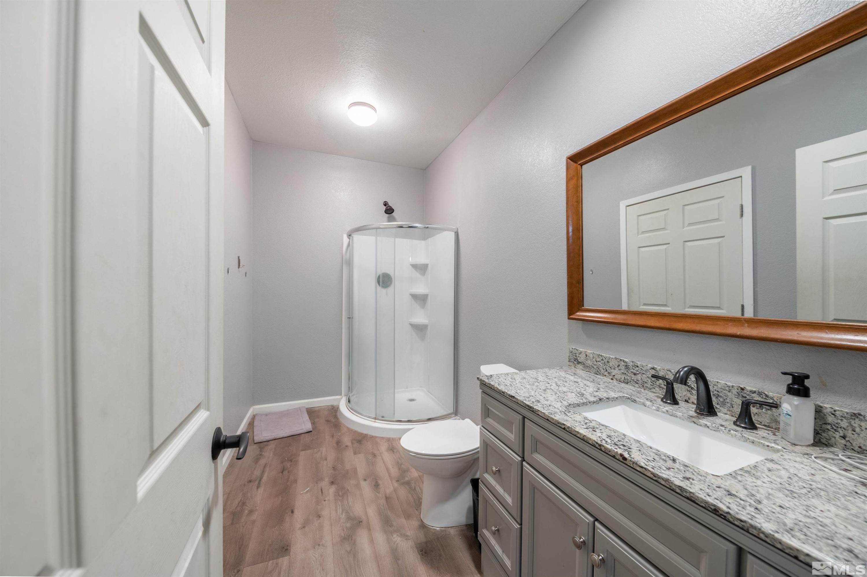 10880 Deodar Way Reno, NV 89506 - Photo 19 of 38 a bathroom with a granite countertop sink toilet and shower