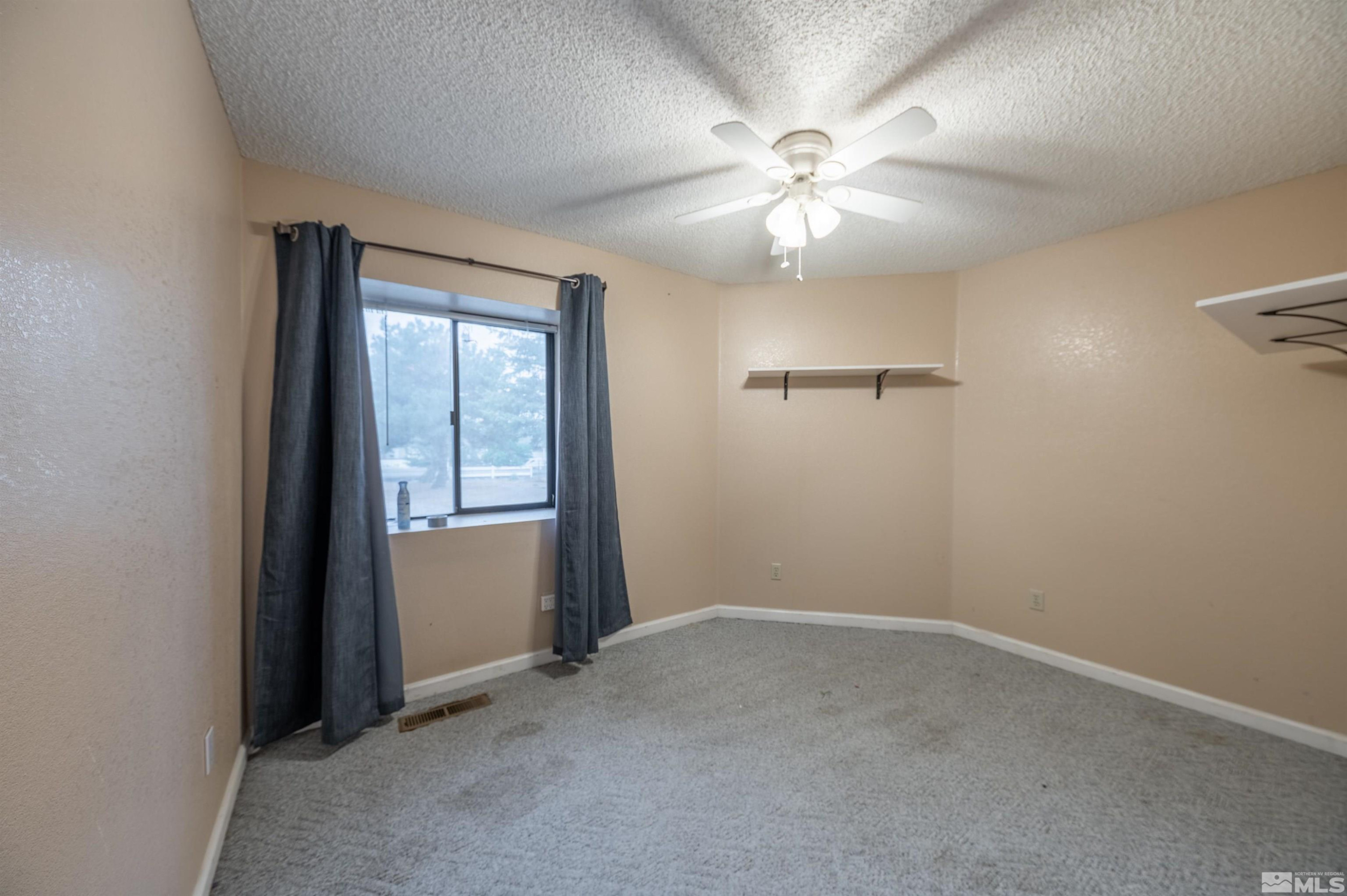 10880 Deodar Way Reno, NV 89506 - Photo 23 of 38 an empty room with windows and fan