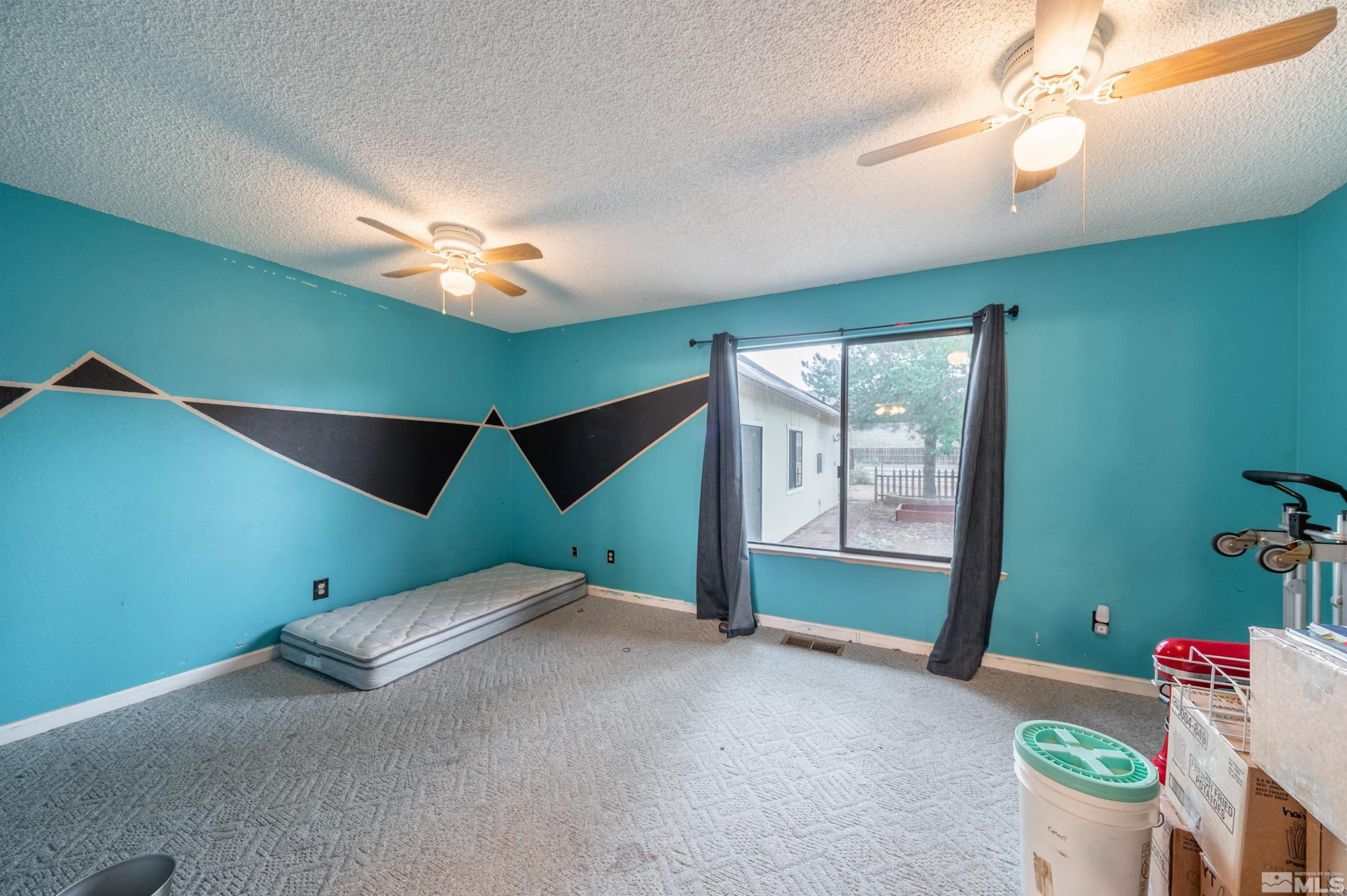 10880 Deodar Way Reno, NV 89506 - Photo 24 of 38 a bed room with a bed and a chandelier