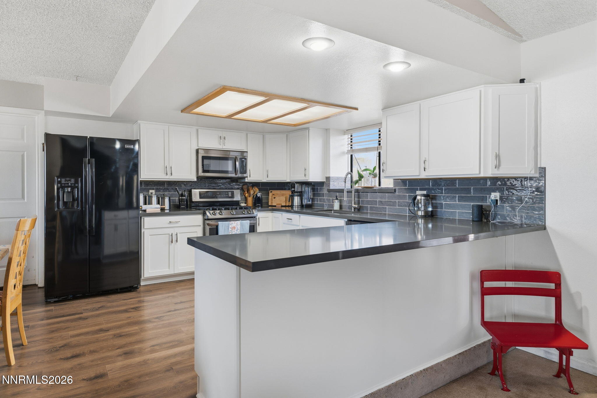 10880 Deodar Way Reno, NV 89506 - Photo 10 of 38 a kitchen with stainless steel appliances granite countertop a stove a sink and a refrigerator