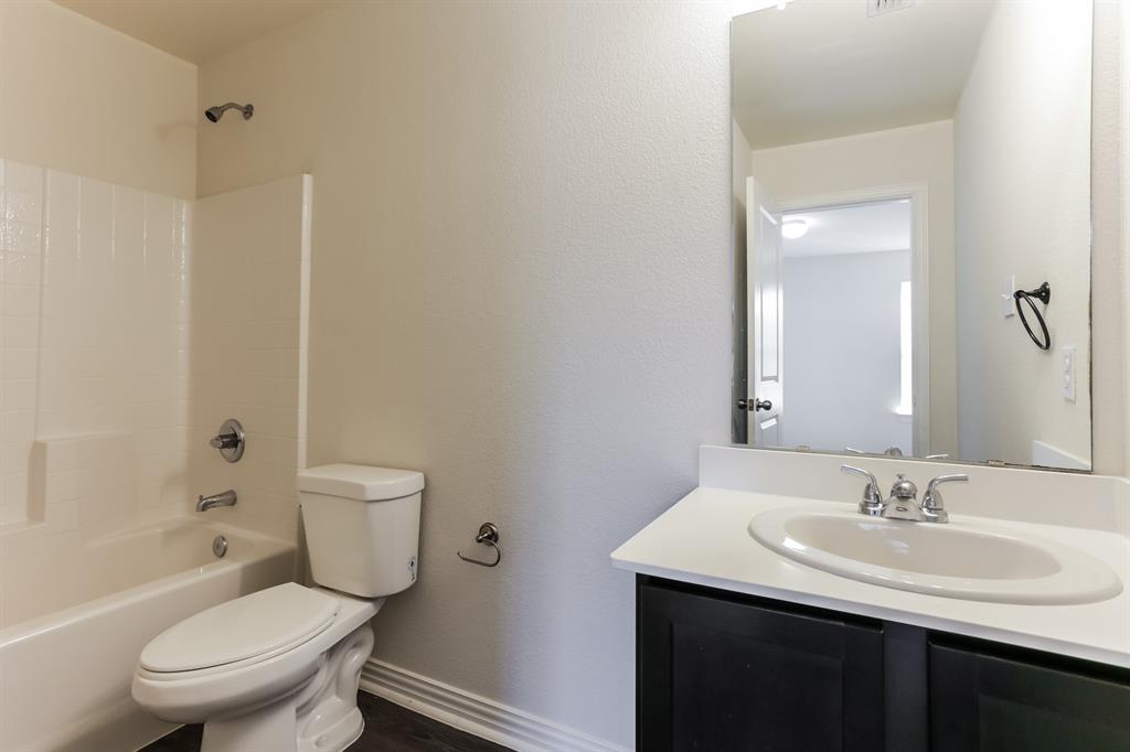 408 Jonathan Street Athens, TX 75751 - Photo 12 of 21 a bathroom with a toilet a sink a mirror and a bathtub