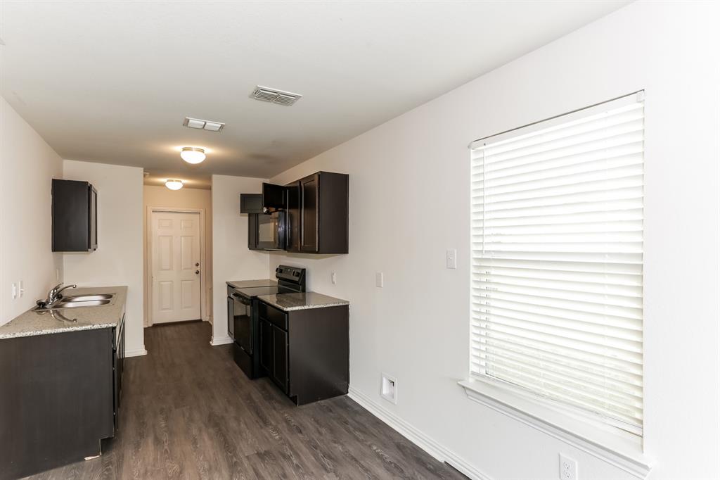 408 Jonathan Street Athens, TX 75751 - Photo 7 of 21 a kitchen with stainless steel appliances granite countertop a refrigerator and a stove top oven