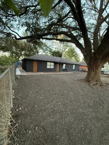 a view of house with a large tree