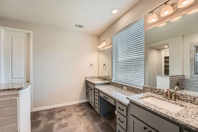 a spacious bathroom with a granite countertop sink and a mirror