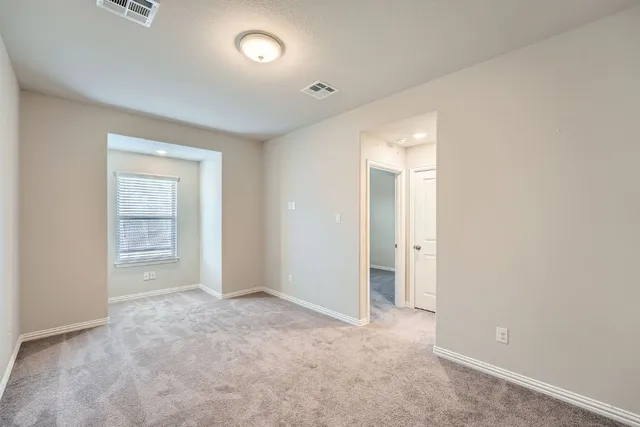an empty room with closet and a bathroom