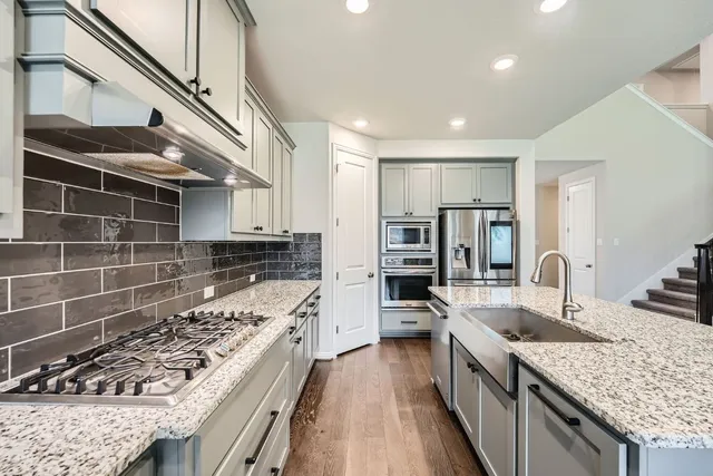 a kitchen with stainless steel appliances granite countertop a sink stove and refrigerator