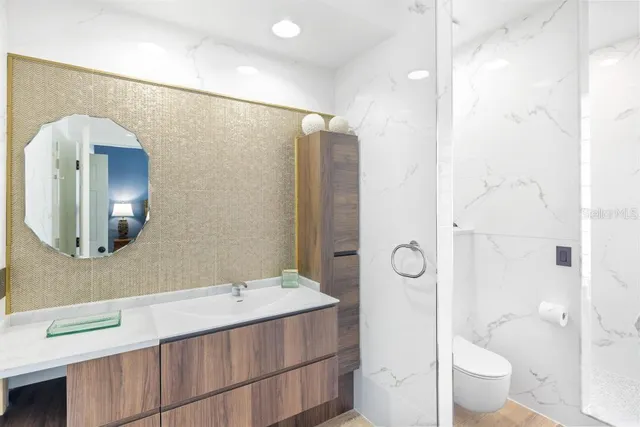 a white toilet sitting next to a shower