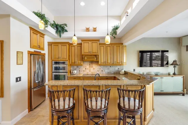 a kitchen with kitchen island granite countertop a sink a counter top space and living room view
