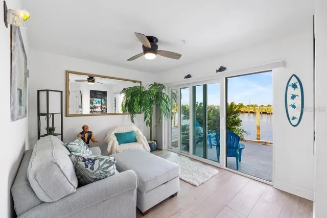 a living room with furniture potted plant and a large window