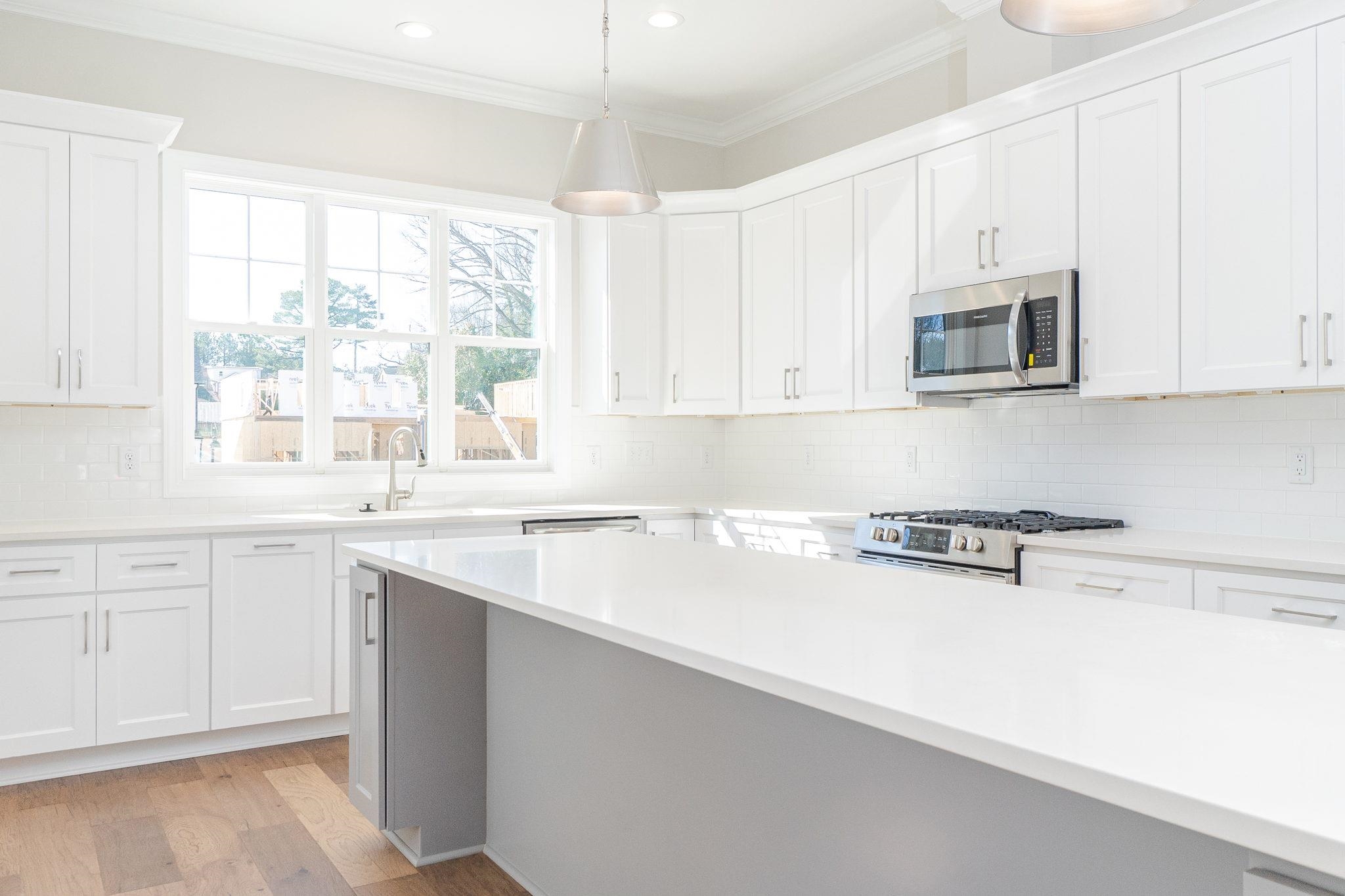 4916 Trek Lane Raleigh, NC 27606 - Photo 13 of 28 a kitchen with stainless steel appliances granite countertop a stove a sink and white cabinets