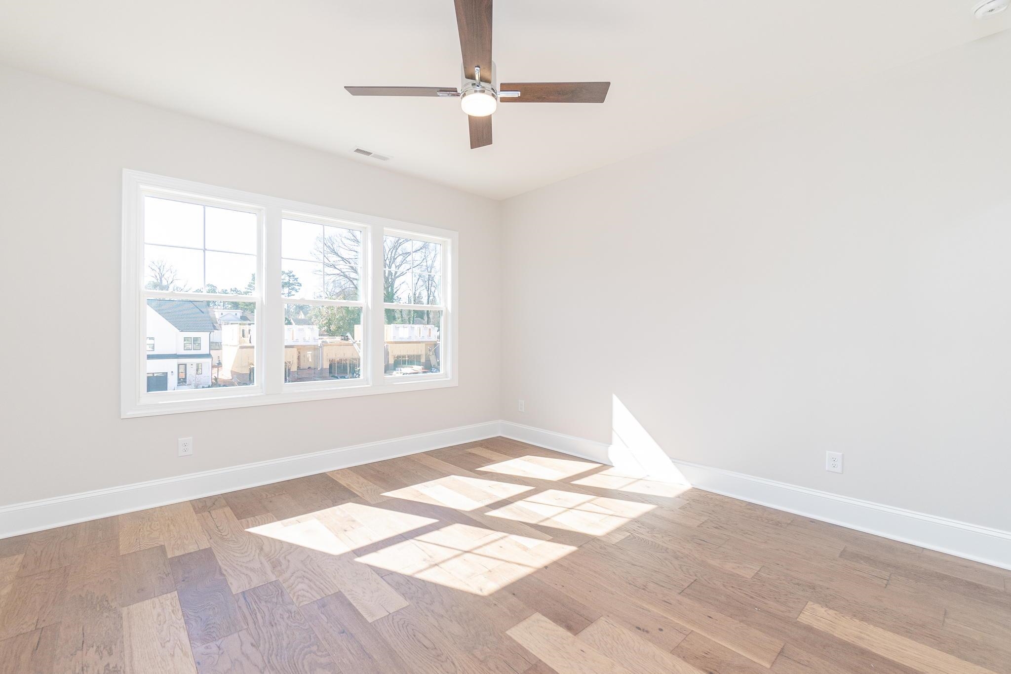 4916 Trek Lane Raleigh, NC 27606 - Photo 18 of 28 an empty room with wooden floor fan and windows