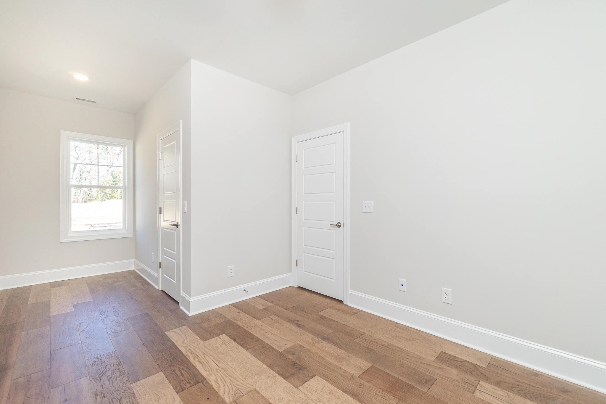 4916 Trek Lane Raleigh, NC 27606 - Photo 24 of 28 an empty room with wooden floor and windows