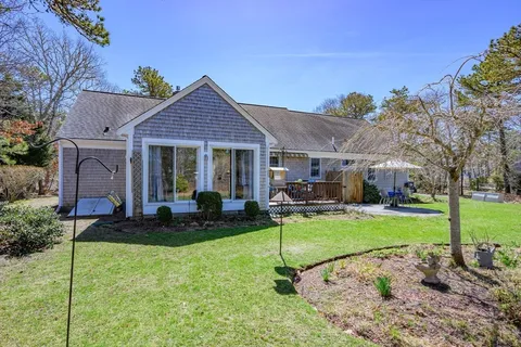a view of a house with backyard sitting area and garden