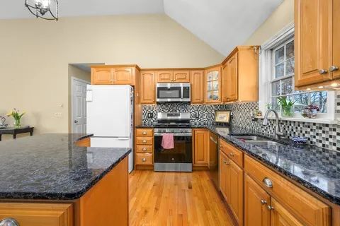 a kitchen with stainless steel appliances granite countertop a sink stove and cabinets